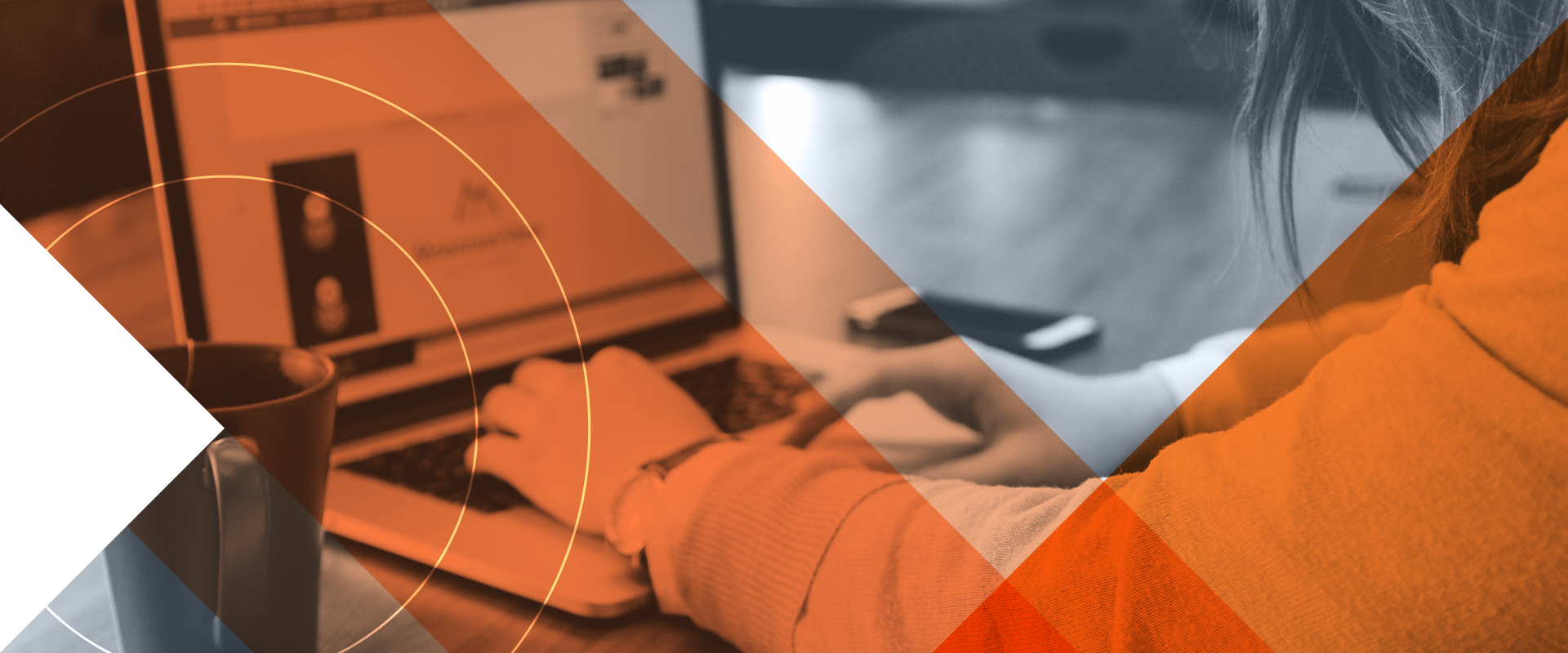 An image showing a woman typing on a computer with notes written on paper beside her.