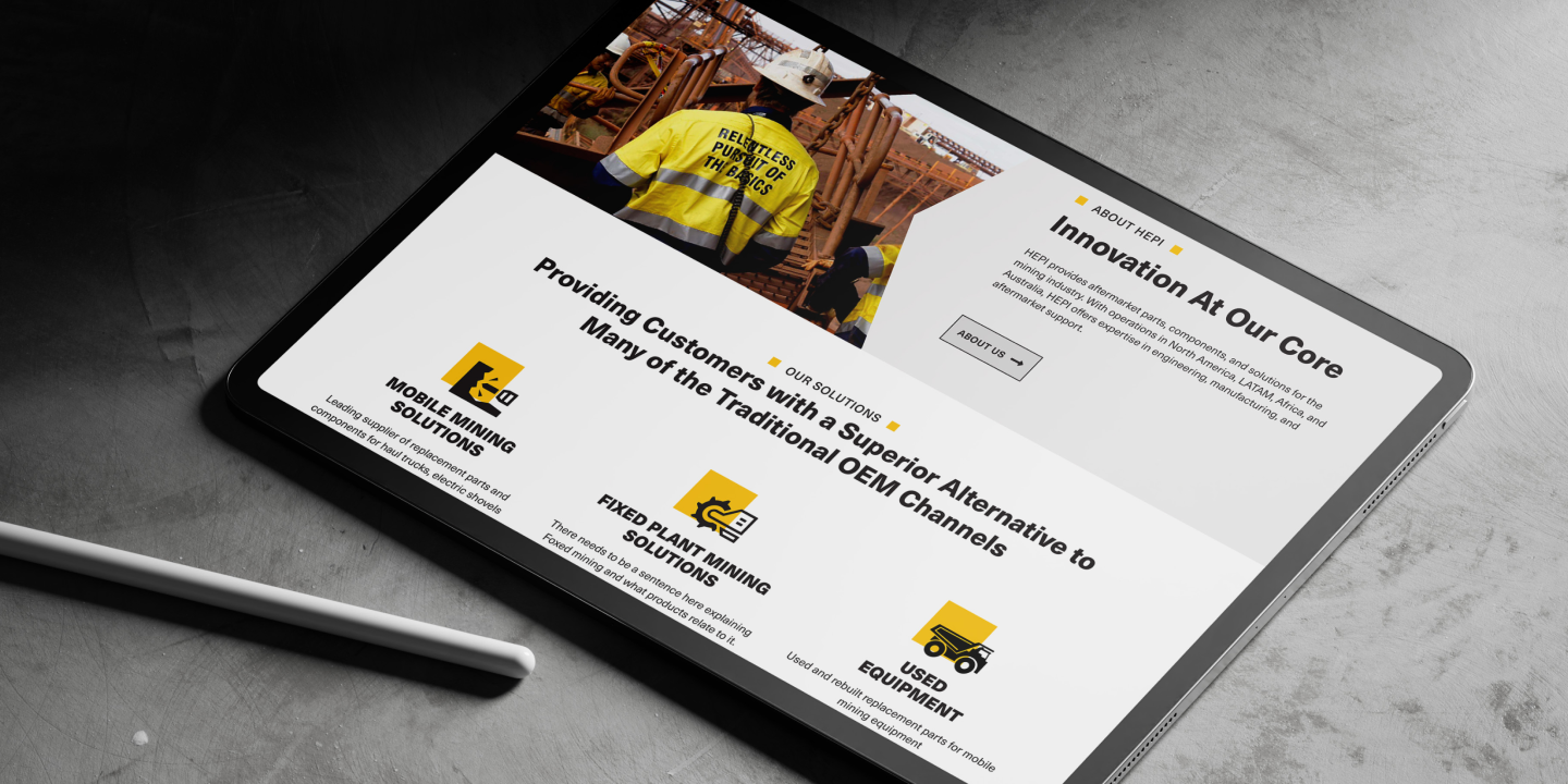 Tablet showing the HEPI website with a hero image of mining workers and section highlighting Mobile Mining Solutions, Fixed Plant Mining Solutions, and Used Equipment.