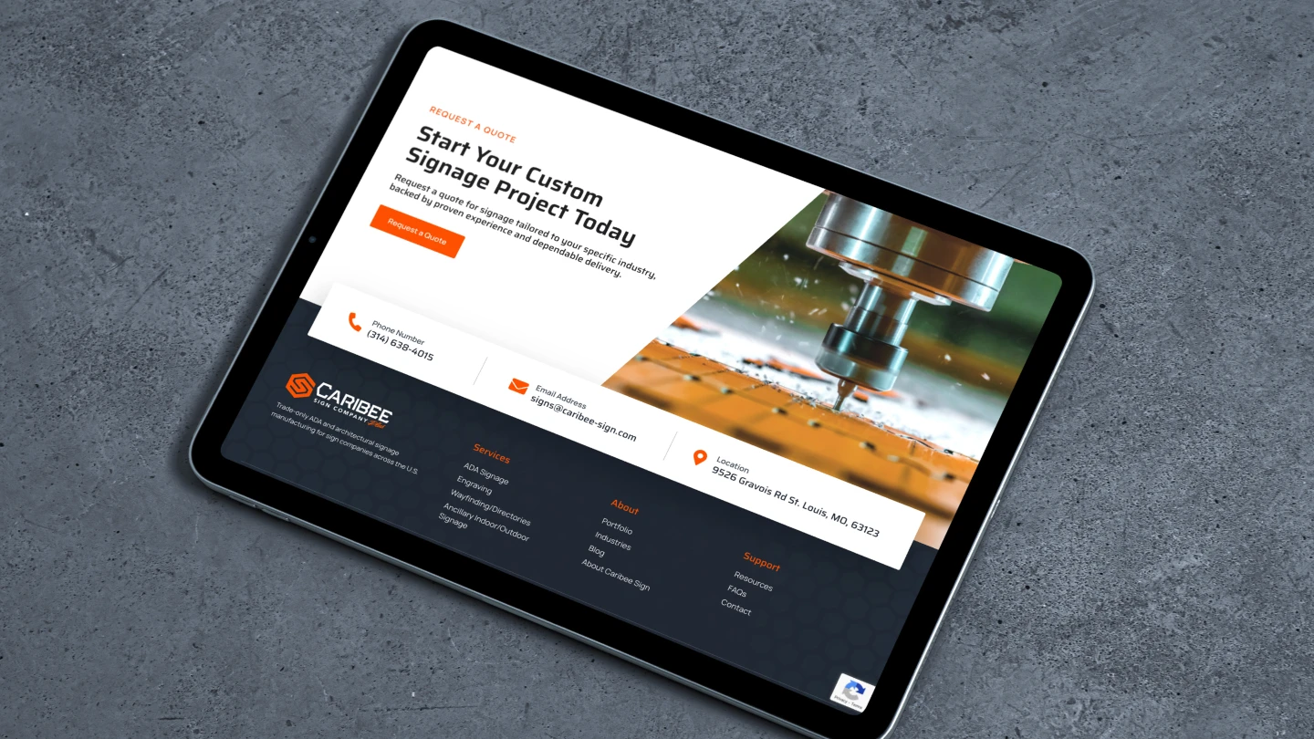 Tablet on a gray surface displaying a website offering custom signage services, featuring a CNC machine image, contact details, and a button for project quotes.