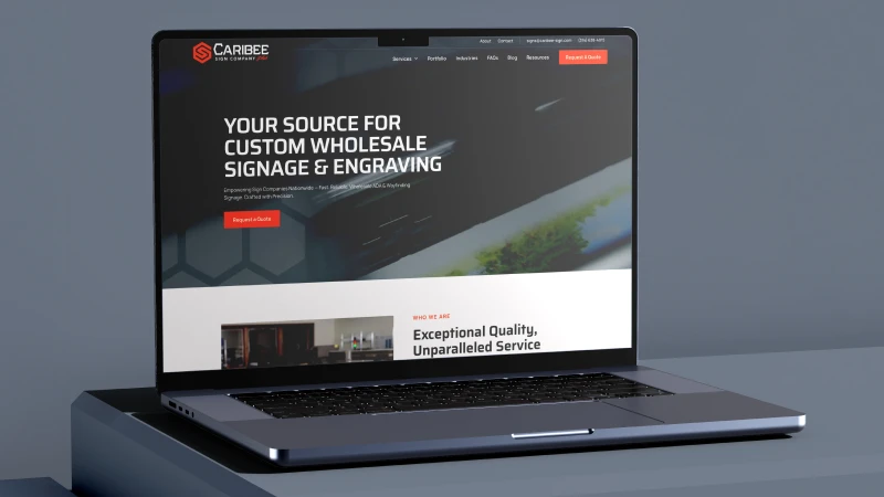 Silver laptop displaying Caribee Sign Company website