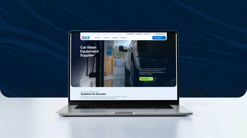 Laptop displaying a website for a car wash equipment supplier, featuring a vehicle being cleaned. The website has a modern, professional design.