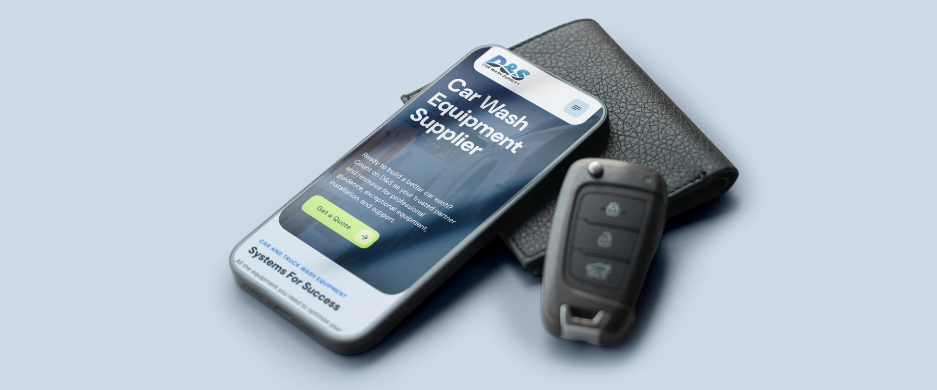 Smartphone displaying a car wash equipment supplier app on a blue background, with a car key fob and wallet nearby.
