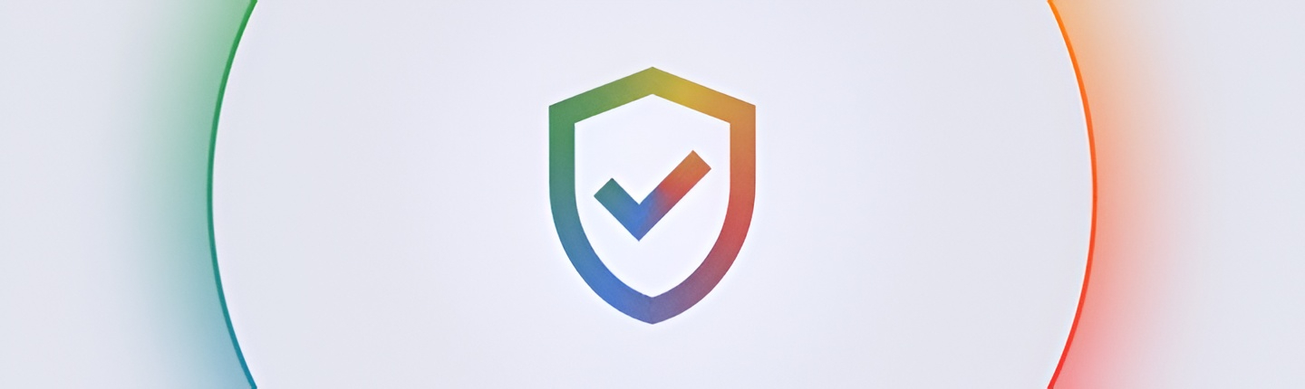 Colorful shield logo with a checkmark centered on a pale white circular backdrop, suggesting security or verification