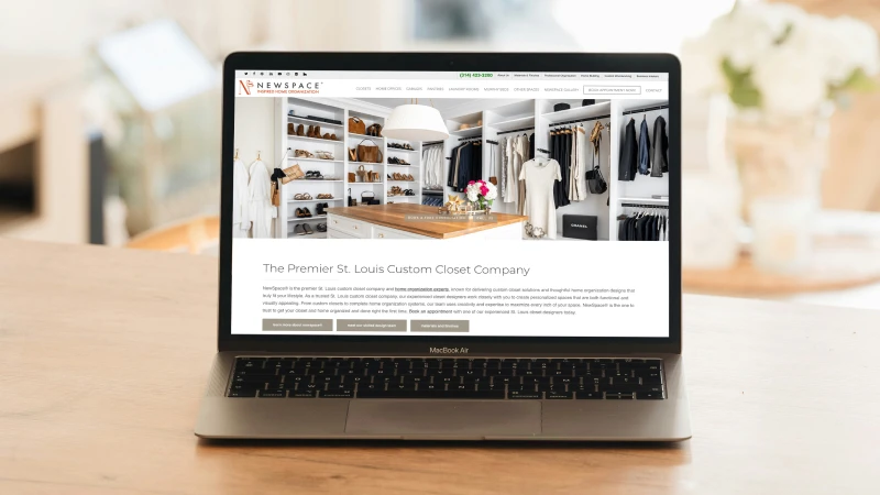 Laptop displaying the NewSpace Home Organization website homepage featuring a custom walk-in closet design, representing custom closets and home organization solutions in the St. Louis area.